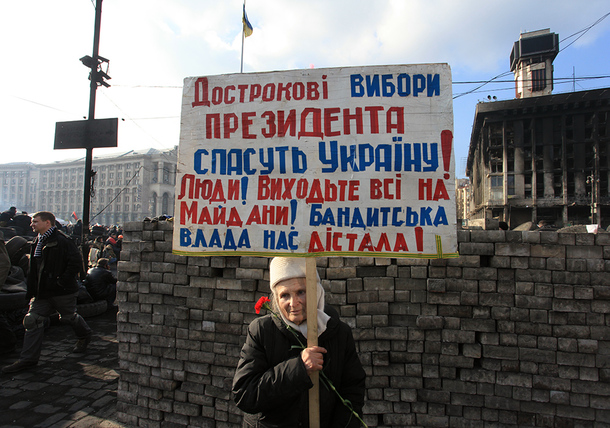 A woman holds a sign on Institutska Street that reads %22New presidential elections will save the country. photo: Pavlo Podufalov
