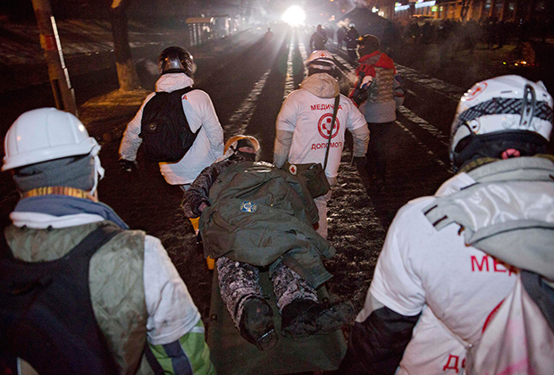 Medical workers transport a wounded protester. Photo by Yevgeniy Feldman / AP