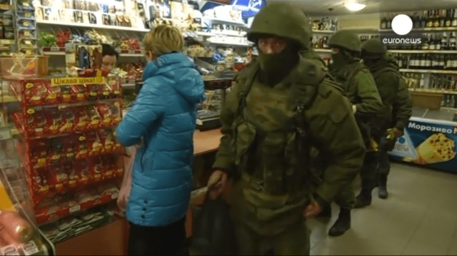 Euronews video still of masked men in Crimean grocery store.