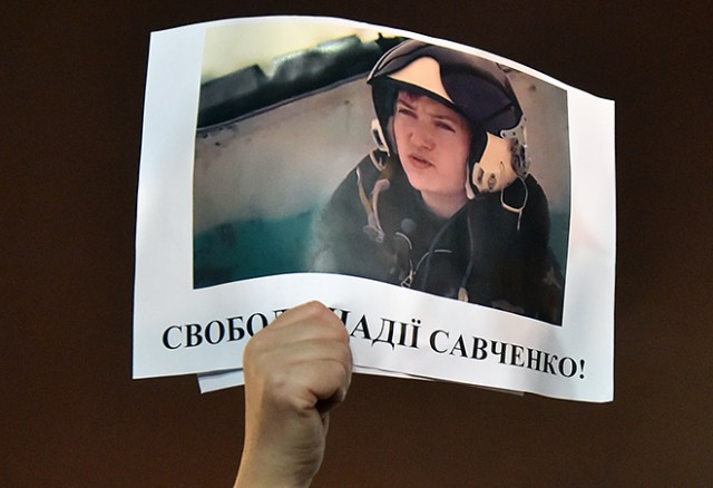 A demonstrator holds aloft a picture of Ukranian army officer captured by pro-Russian insurgents, Nadiya Savchenko , bearing the slogan "Free Nadiya Savchenko" during a rally on Independence Square in Kiev on January 26, 2015 demanding her liberation during an International day of support for her. The first lieutenant of the Ukrainian airforce, helicopter pilot Nadiya Savchenko was fighting in a Ukrainian volunteer battalion in east of the country and captured by pro-Russian insurgents in eastern Ukraine, later handed over to Russia, and charged with the killing of two Russian journalists during the 2014 insurgency in Donbass. AFP PHOTO/ SERGEI SUPINSKY