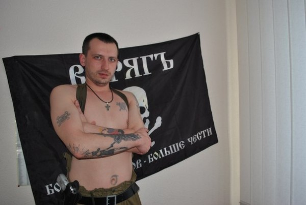 Matyushin posing with the Varyag squad flag. The motto reads: More enemies - more honor.