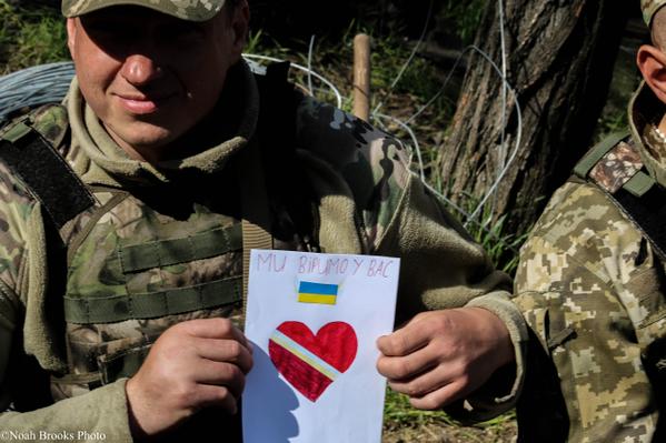 Ukrainian soldier with letter from child that reads: "We believe in you." Photo: Noah Brooks. Source