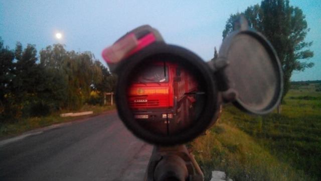 Ukrainian soldier and  sniper keeps watch through his scope at a checkpoint as full moon rises. Photo: Mykola Voronin