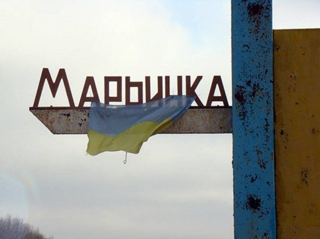 Ukrainian flag hanging from the town marker in Mar'inka